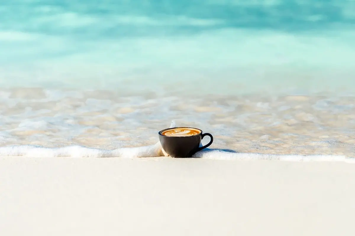 Slut med at drikke kedelig kaffe på stranden